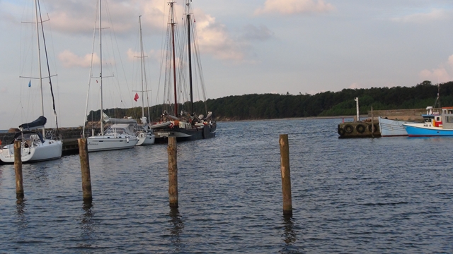  Lege boxen en een platbodem waarvan de boegspriet buiten de haven uit steekt